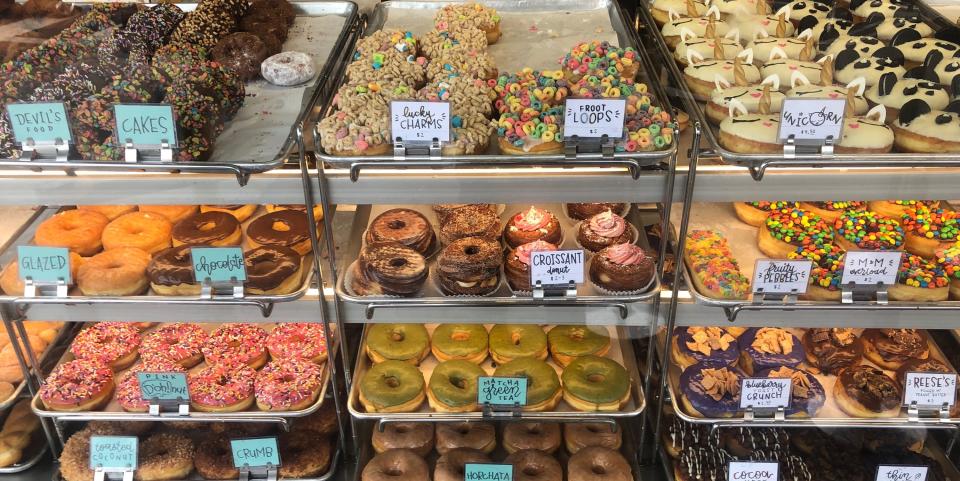 Trays of donuts behind glass in a donut shop