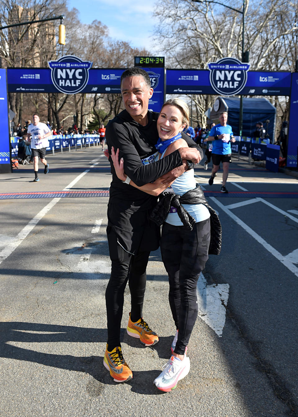 TJ Holmes and Amy Robach celebrate as they cross the finish line during the 2022 United Airlines NYC Half Marathon on March 20, 2022 in New York City. (Photo by Bryan Bedder/New York Road Runners via Getty Images)