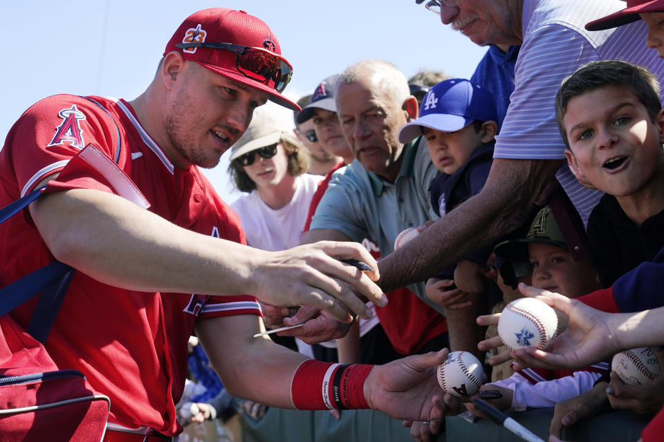Los Angeles Angels' Mike Trout signs autographs for fans prior to the team's spring training baseball game against the Los Angeles Dodgers on Friday, March 3, 2023, in Tempe, Ariz. (AP Photo/Ross D. Franklin)