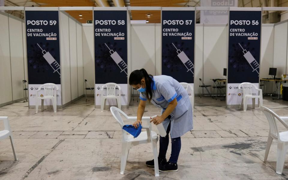 A staff member cleans a chair as preparations are under way for the opening of the biggest coronavirus disease vaccination center in Lisbon - Reuters