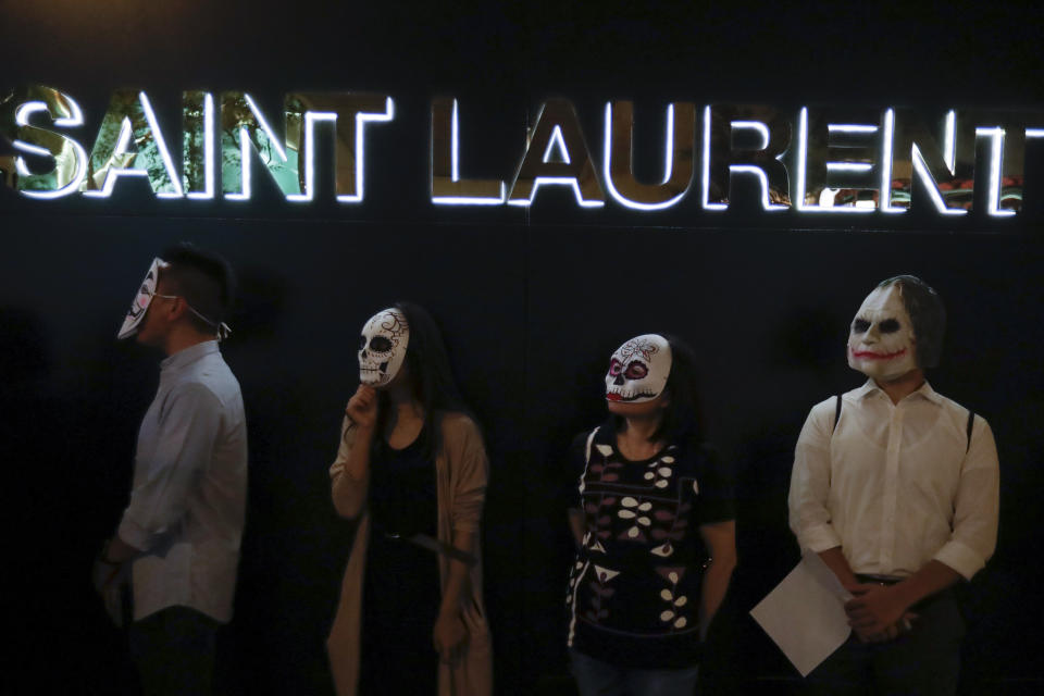 Protesters wear masks during a protest in Hong Kong, Friday, Oct. 18, 2019. Hong Kong pro-democracy protesters are donning cartoon/superhero masks as they formed a human chain across the semiautonomous Chinese city, in defiance of a government ban on face coverings. (AP Photo/Mark Schiefelbein)