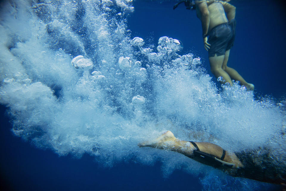 Walter Denton dives into the ocean while swimming with his brother in Agat, Guam, Saturday, May 11, 2019. "Being out there, on the water, it's comforting. I just look around. It takes me to a different place," said Denton, whose recent return to live on the island he credits as helping him cope with the night he says a priest raped him when he was 13. "When you're out there all your worries and troubles that you've gone through it kind of goes away. You don't think about anything else. It's so peaceful." Former Archbishop of Agana, Anthony Apuron denies the allegations, which are detailed in a lawsuit. (AP Photo/David Goldman)