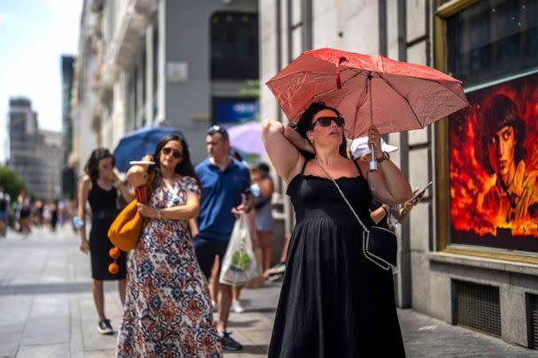 PHOTO: A woman holds an umbrella to shelter from the sun during a hot sunny day in Madrid, July 18, 2022. (Manu Fernandez/AP)