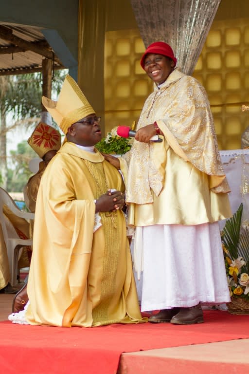 Vicentia Tadagbe Tchranvoukinni (R) stands next to Mathias Vignan, alia Pope Christophe XVIII of the Very Holy Church of Jesus Christ of Baname, at the Nazareth church in Djidja, Benin