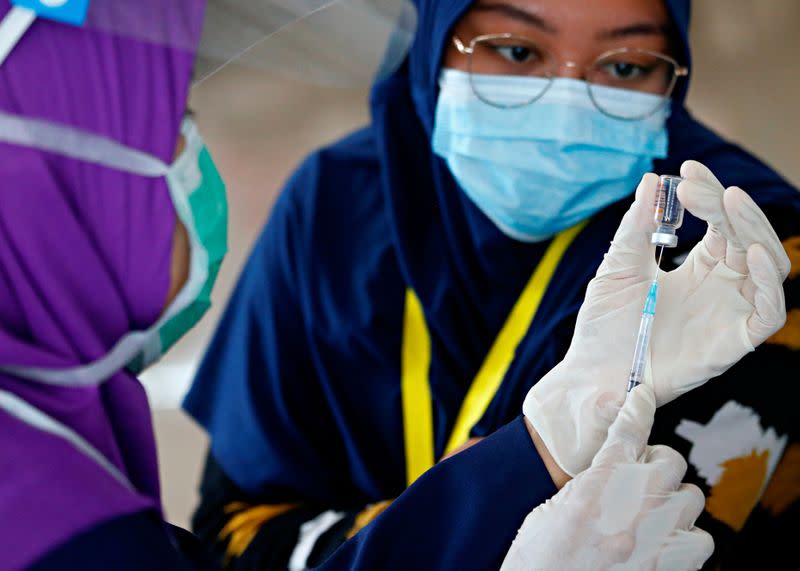 A medical worker prepares a dose of the Sinovac's vaccine before giving it to a healthcare worker at the emergency hospital for the coronavirus disease (COVID-19) patients in the Athlete Village in Jakarta