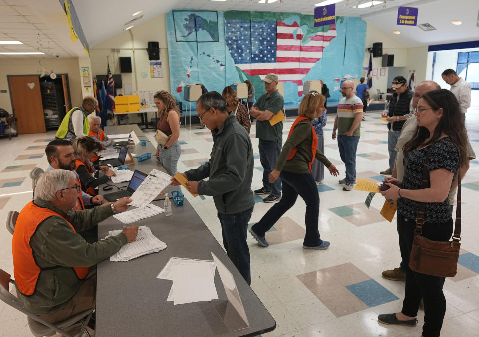 People line up to vote in front of a mural at a Elementary school polling station Tuesday Nov. 7, 2023, in Midlothian, Va. (AP Photo/Steve Helber)