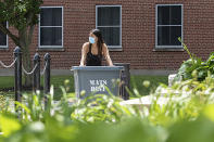 In this photo provided by Marilyn Hesler and Syracuse University, a student wearing a mask wheels her belongings up a ramp to move into her dorm, Sunday, Aug. 2, 2020, at Syracuse University in Syracuse, N.Y. (Marilyn Hesler/Syracuse University via AP)