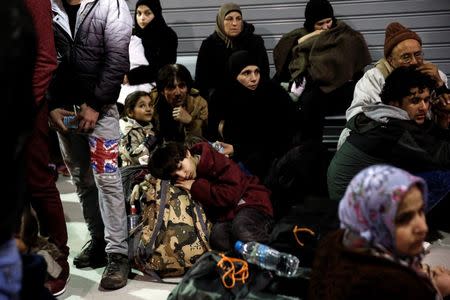 Refugees and migrants rest inside a terminal, following their arrival aboard the passenger ferry Blue Star Patmos at the port of Piraeus, near Athens, Greece, February 22, 2016. REUTERS/Alkis Konstantinidis