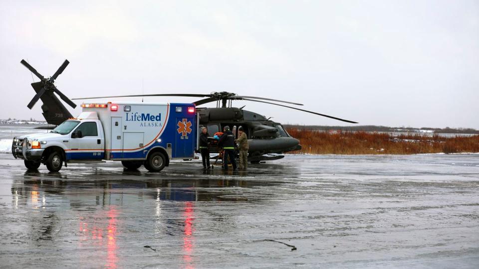 This photo provided by the Alaska National Guard shows, from the left, Holly Demmert and Clifton Dalton, both flight paramedics with LifeMed, and Chief Warrant Officer 3 Bryan Kruse, Bethel Army Aviation Operating Facility commander, move a critically ill patient from an AKARNG UH-60L Black Hawk helicopter to an ambulance during a medical evacuation from Napaskiak to Bethel, Wednesday, Nov. 15, 2023 in Bethel, Alaska. (Balina O'Neal/Alaska National Guard via AP)