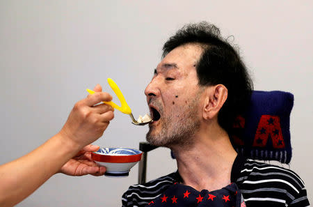 A caretaker gives food to congenital Minamata disease patient Yuji Kaneko at Oruge-Noa, a group care home for disabled people including Minamata disease patients, in Minamata, Kumamoto Prefecture, Japan, September 13, 2017. REUTERS/Kim Kyung-Hoon