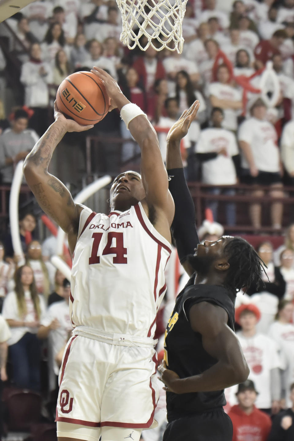 Oklahoma forward Jalon Moore, left, shoots the ball over Arkansas-Pine Bluff forward Ismael Plet, right, during the first half of an NCAA college basketball game in Norman, Okla., Thursday, Nov. 30, 2023. (AP Photo/Kyle Phillips)