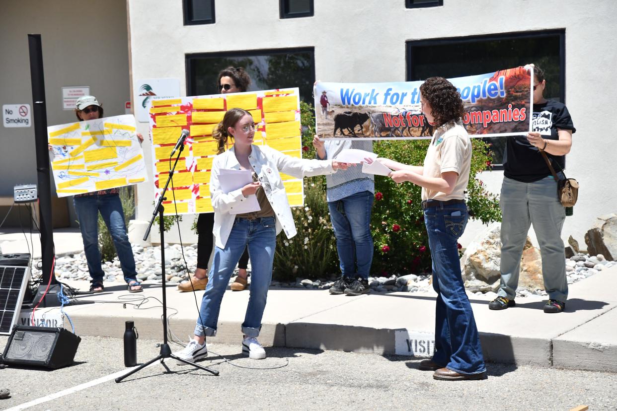 Allison Sandoval, Public Affairs Specialist for the Bureau of Land Management receives reports justifying immediate phase out of fossil fuel production and a letter signed by over 270 groups calling for an end to federal fossil fuel leasing, delivered by Kayley Shoup of Citizens Caring for the Future in Carlsbad, May 25 in Santa Fe.