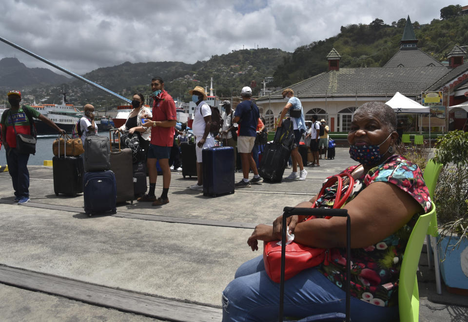 British, Canadian and U.S. nationals wait to board the Royal Caribbean cruise ship Reflection to be evacuated free of charge, in Kingstown on the eastern Caribbean island of St. Vincent, Friday, April 16, 2021. La Soufriere volcano has shot out another explosive burst of gas and ash Friday morning as the cruise ship arrived to evacuate some of the foreigners who had been stuck on a St. Vincent island by a week of violent eruptions. (AP Photo/Orvil Samuel)