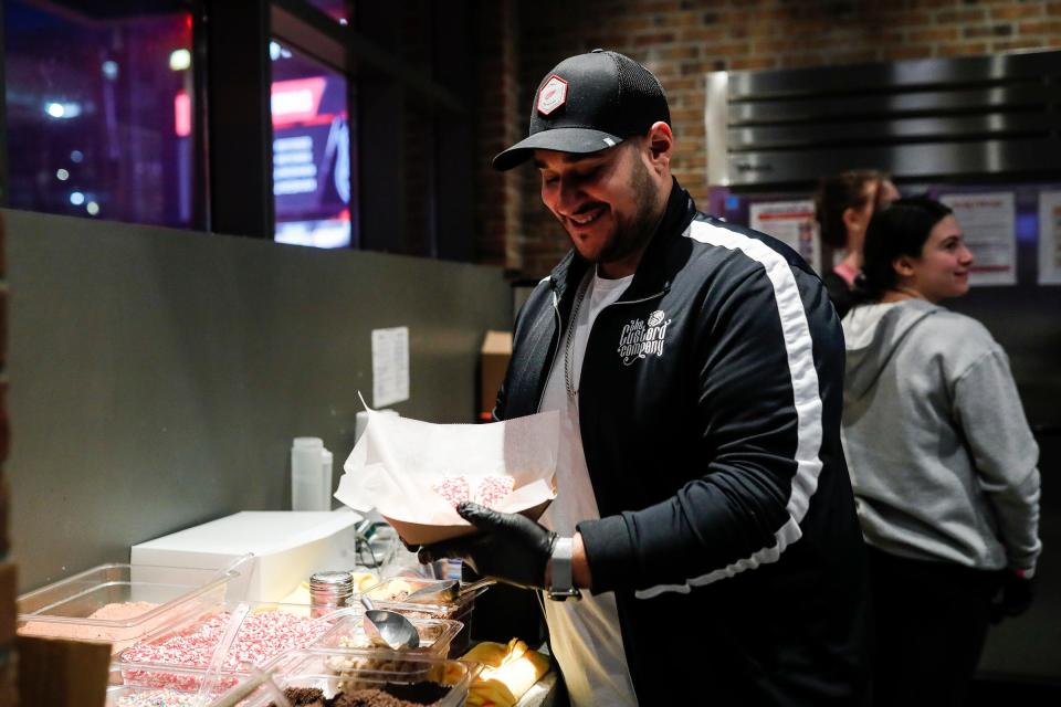 Jamal Jawad prepares a Wings Sweet Bun at the Custard Co. stand before a Red Wings game at Little Caesars Arena in Detroit on Wednesday, March 8, 2023.