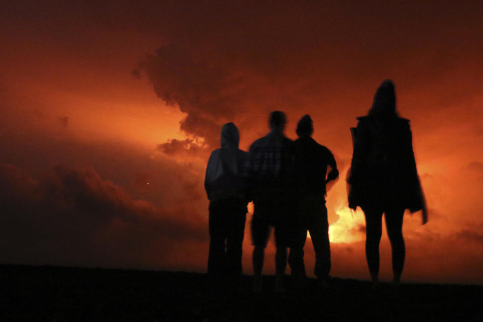 People watch the glow from lava erupting from Hawaii's Mauna Loa volcano Nov. 28, 2022, in Hilo, Hawaii. / Credit: AP Photo/Caleb Jones