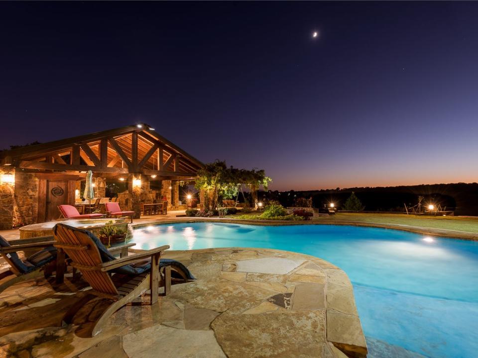 A photo shows a lit-up pool and pool house at night on Terry Bradshaw's ranch.