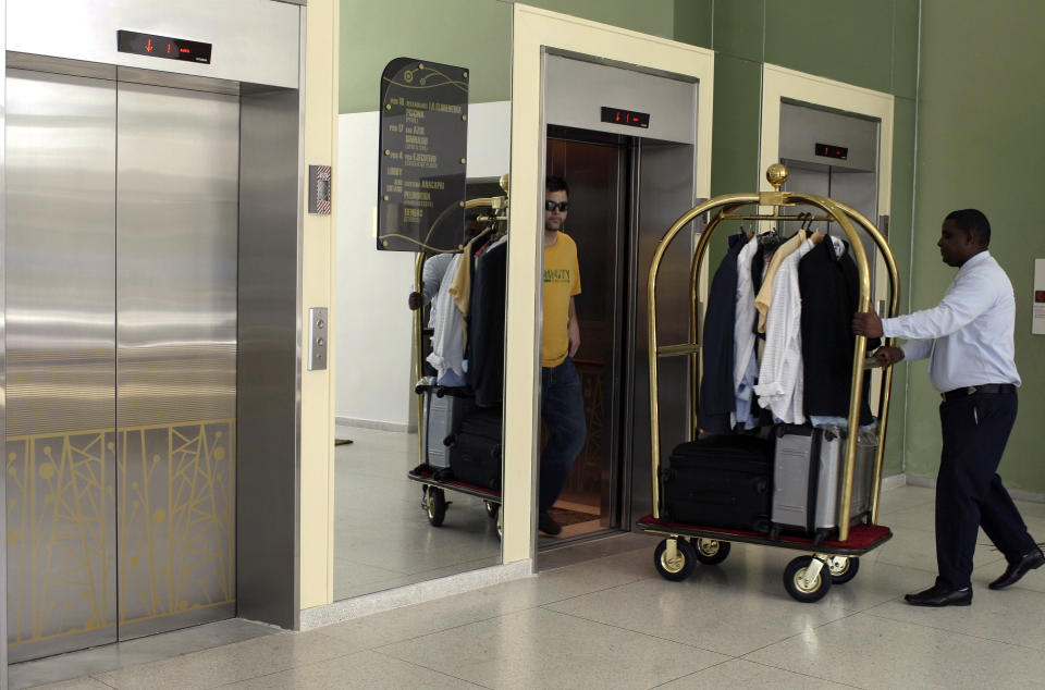 In this Feb. 8, 2014 photo, bellhop Vladimir Pena, right, pushes a guest's luggage to the elevator at the refurbished Capri hotel in Havana, Cuba. The Capri operated as a state-run hotel for decades and at times hosted a different sort of celebrity guest, people such as Cuban crooner Omara Portuondo and left-wing Uruguayan writer Mario Benedetti. In 1997, militant anti-Castro exiles set off a bomb in the lobby that caused severe damage but no fatalities. The Capri survived, but like many buildings it became run-down from lack of maintenance, and closed in the early 2000s. (AP Photo/Franklin Reyes)