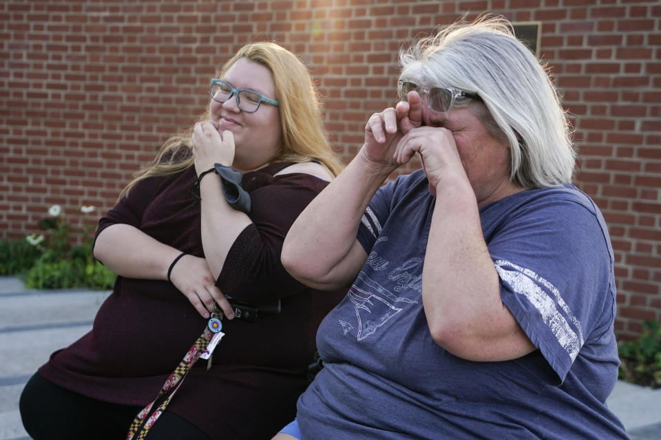 Elyzabeth Marcussen, right, a former community editor at the Annapolis Capital Gazette newspaper, reacts while sitting with her daughter, Haley Marcussen, at the Guardians of the First Amendment memorial, which is dedicated to the victims of the newsroom shooting of 2018, Thursday, July 15, 2021, in Annapolis, Md. Elyzabeth Marcussen left the paper three years prior to the shooting, but still had friendships with staff, including most of the people killed by Jarrod W. Ramos, the gunman which jury found criminally responsible, rejecting defense attorneys' mental illness arguments, on Thursday. (AP Photo/Julio Cortez)