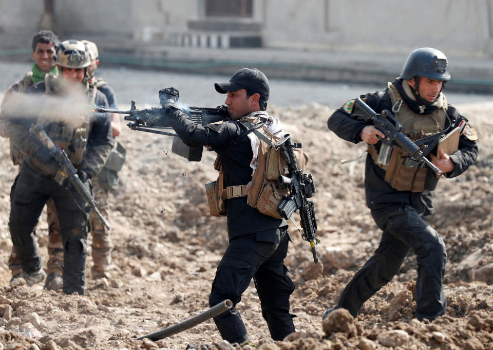 <p>An Iraqi special forces soldier fires as other soldiers runs across a street during a battle in Mosul, Iraq March 1, 2017. (Goran Tomasevic/Reuters) </p>