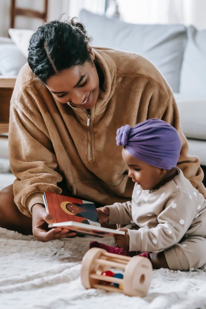 Black mother reading to her infant daughter