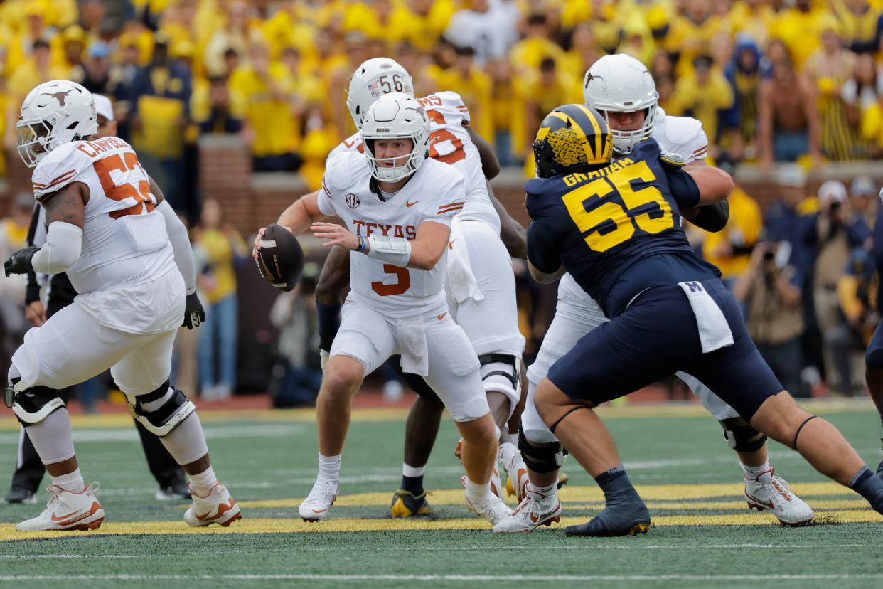 Texas quarterback Quinn Ewers (3) rushes in the first half against Michigan at Michigan Stadium.