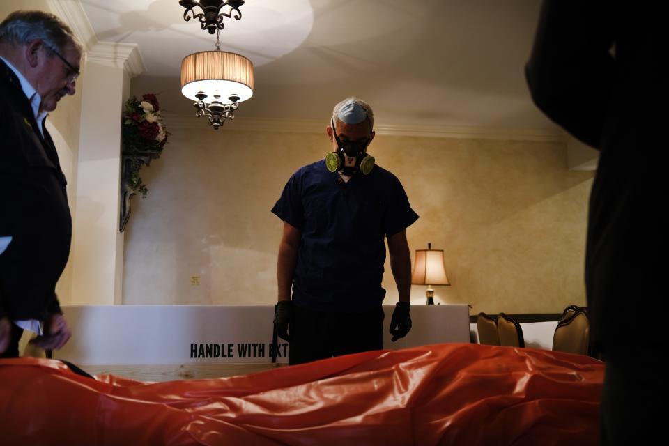 Omar Rodriguez and Ray Neufeld move a body in the Gerard Neufeld funeral home in Queens on April 22 in New York City.