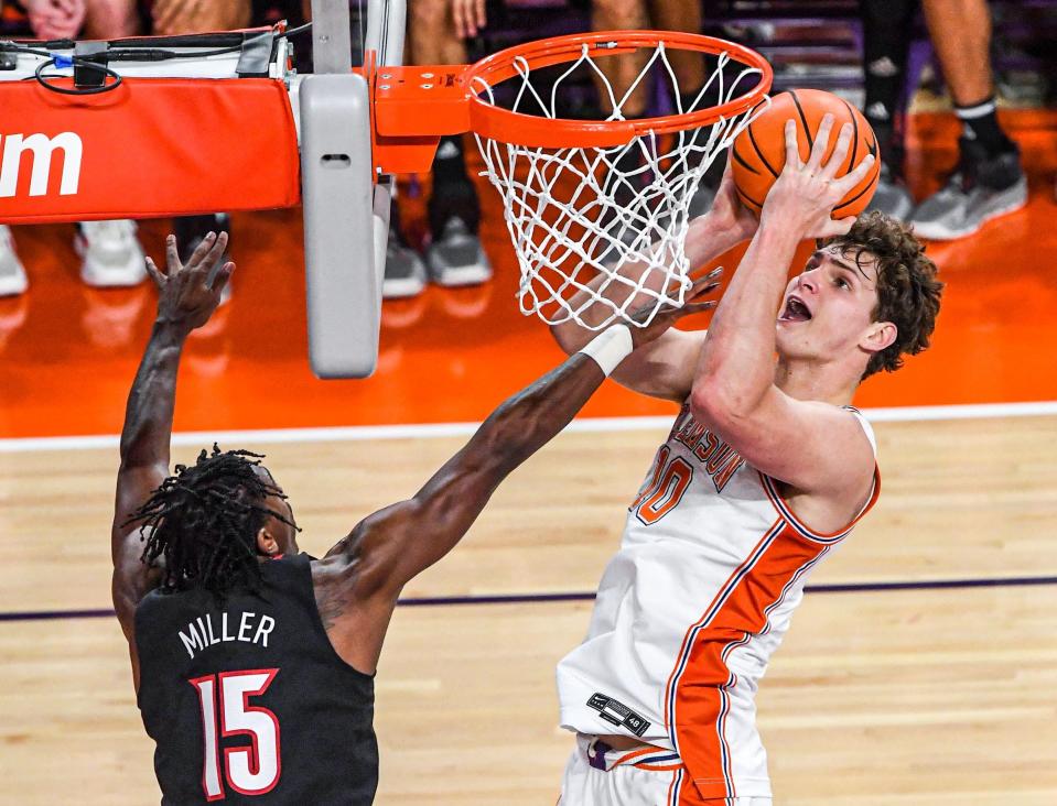 Jan 11, 2023; Clemson, South Carolina, USA; Clemson Tigers forward Ben Middlebrooks (10) scores near Louisville Cardinals guard Hercy Mller (15) during the first half at Littlejohn Coliseum. Mandatory Credit: Ken Ruinard-USA TODAY Sports