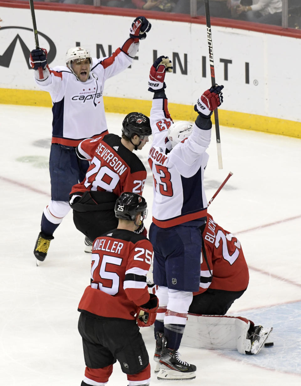 Washington Capitals right wing Tom Wilson (43) celebrates his goal with left wing Alex Ovechkin (8) as New Jersey Devils defenseman Damon Severson (28) and defenseman Mirco Mueller (25) react during the second period of an NHL hockey game Saturday, Feb. 22, 2020, in Newark, N.J. (AP Photo/Bill Kostroun)
