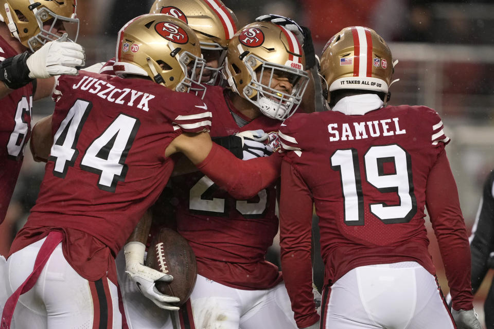 San Francisco 49ers running back Elijah Mitchell, middle, is congratulated by teammates after scoring against the Indianapolis Colts during the first half of an NFL football game in Santa Clara, Calif., Sunday, Oct. 24, 2021. (AP Photo/Tony Avelar)