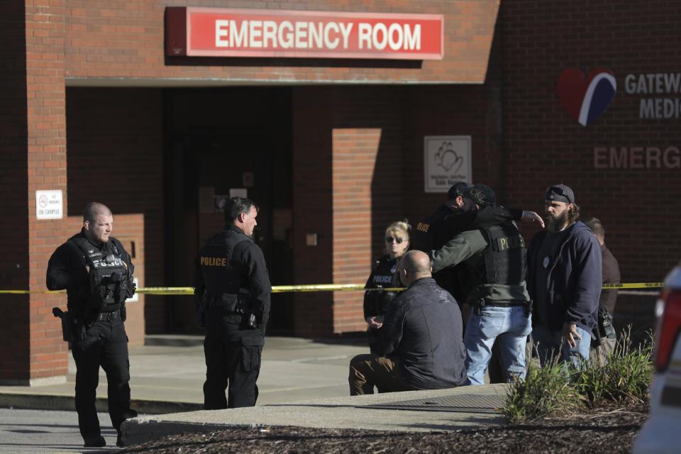 ADDS THAT POLICE OFFICER HAS DIED - Police officers embrace while waiting outside the emergency room at Gateway Medical Center in Granite City, Ill., on Tuesday, Oct. 26, 2021. A police officer died Tuesday after being shot by a man at gas station in an Illinois suburb of St. Louis, authorities said. (Colter Peterson/St. Louis Post-Dispatch via AP)