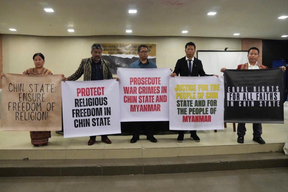 Relatives of victims of deadly attacks by their government’s military hold slogans after filing a criminal complaint against Myanmar’s top generals (AP)