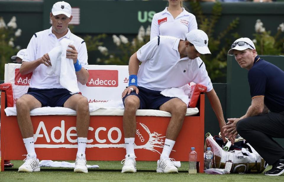 FILE - In this March 5, 2016 file photo, Jim Courier, right, captain of the United States Davis Cup team, talks to doubles players Bob, left, and Mike Bryan while playing against Australia's Lleyton Hewitt and John Peers during their Davis Cup doubles match in Melbourne, Australia. Bob and Mike Bryan announced Sunday, January, 22, 2017, that they are retiring from playing Davis Cup for the United States after 14 years with the team. (AP Photo/Andrew Brownbill,File)