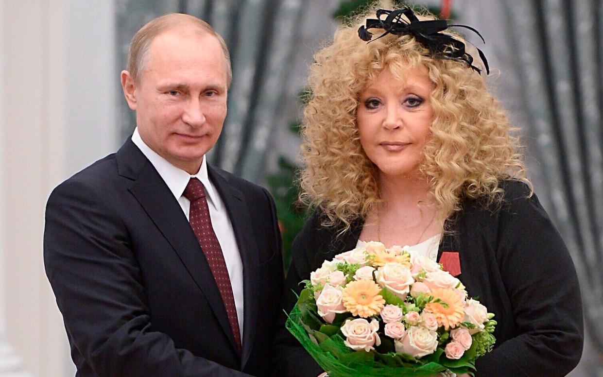 The Russian President and the pop singer pose for a photo - she holds a bunch of flowers
