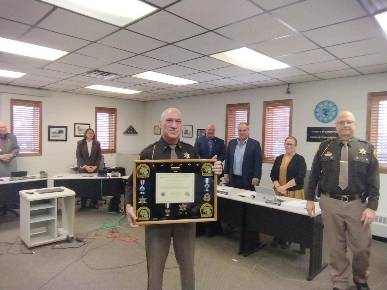 Sheriff Dale Clarmont holds a plaque presented to him from department employees at the Jan. 24 meeting of the Cheboygan County Board of Commissioners. Clarmont is retiring after serving as sheriff for 22 years. Undersheriff Tim Cook, standing to Clarmont's right, will succeed him.