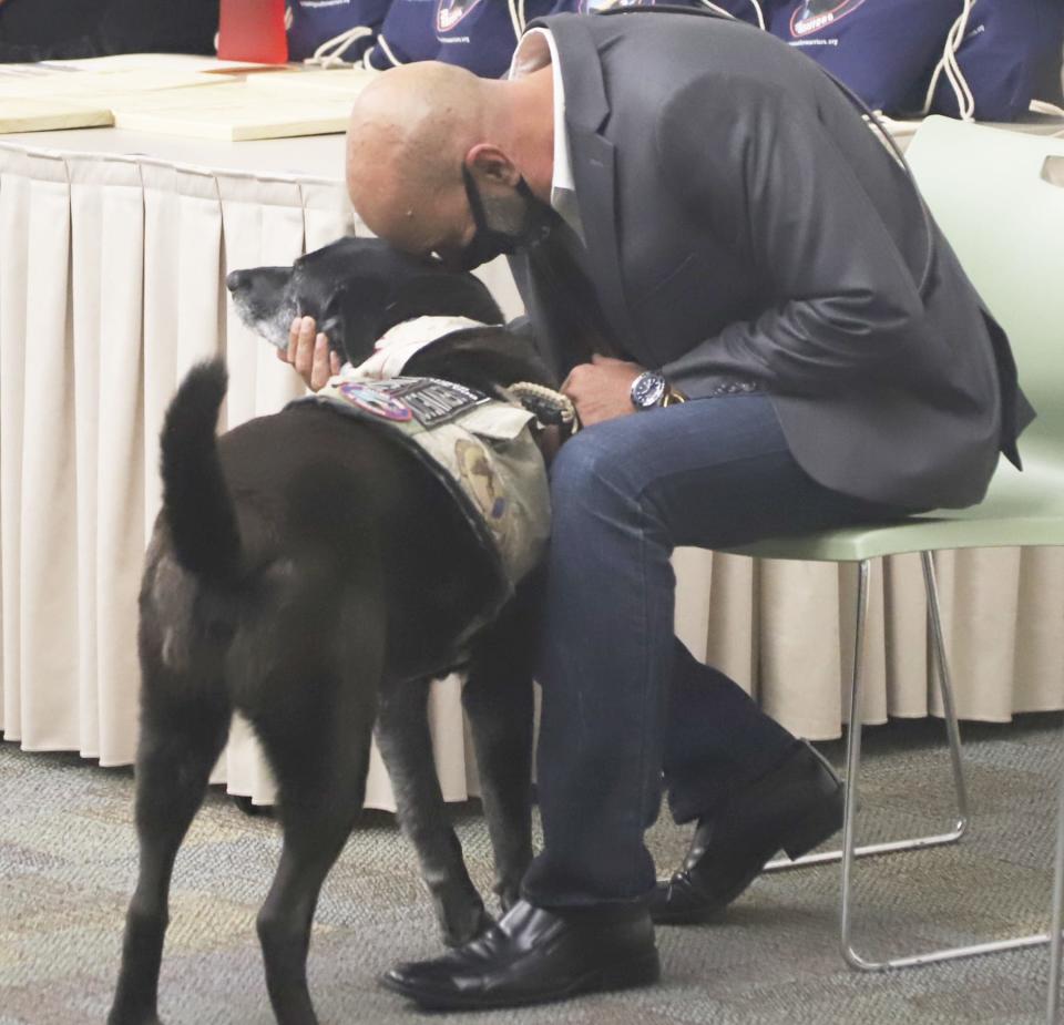 Retired Air Force Master Sgt. Mike Arena, co-founder of Healing Paws for Warriors, gets emotional during the retirement ceremony for his service dog, Orion. Evan Williams Bourbon recently honored Arena as a 2022 American-Made Hero, making him part of a select group of veterans to be featured on the limited-edition Evan Williams American Hero bottles.