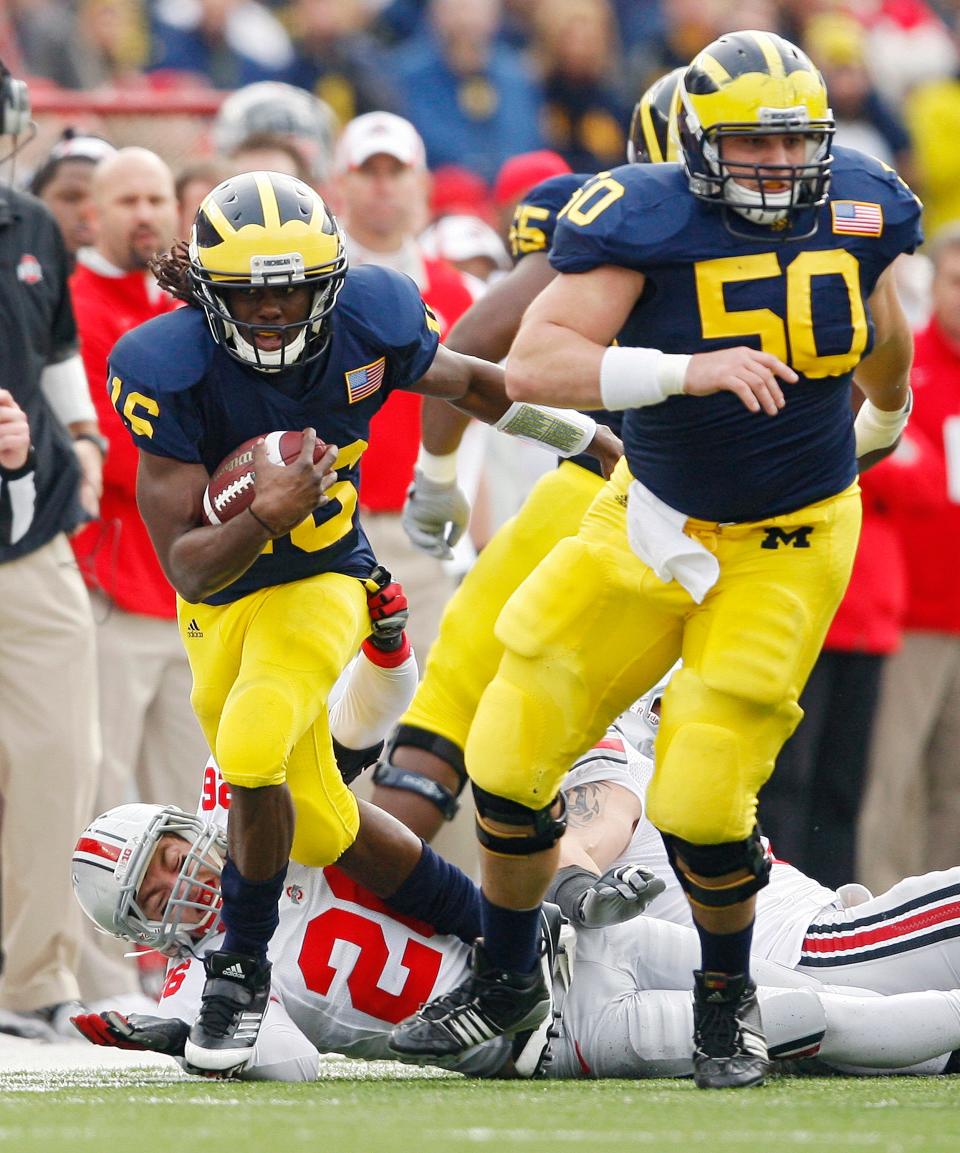 Ohio State Buckeyes linebacker Tyler Moeller (26) tries to tackle Michigan Wolverines quarterback Denard Robinson (16) in the 1st quarter during their NCAA college football game in Michigan Stadium, Ann Arbor, Michigan November 26, 2011. (Dispatch photo by Kyle Robertson)