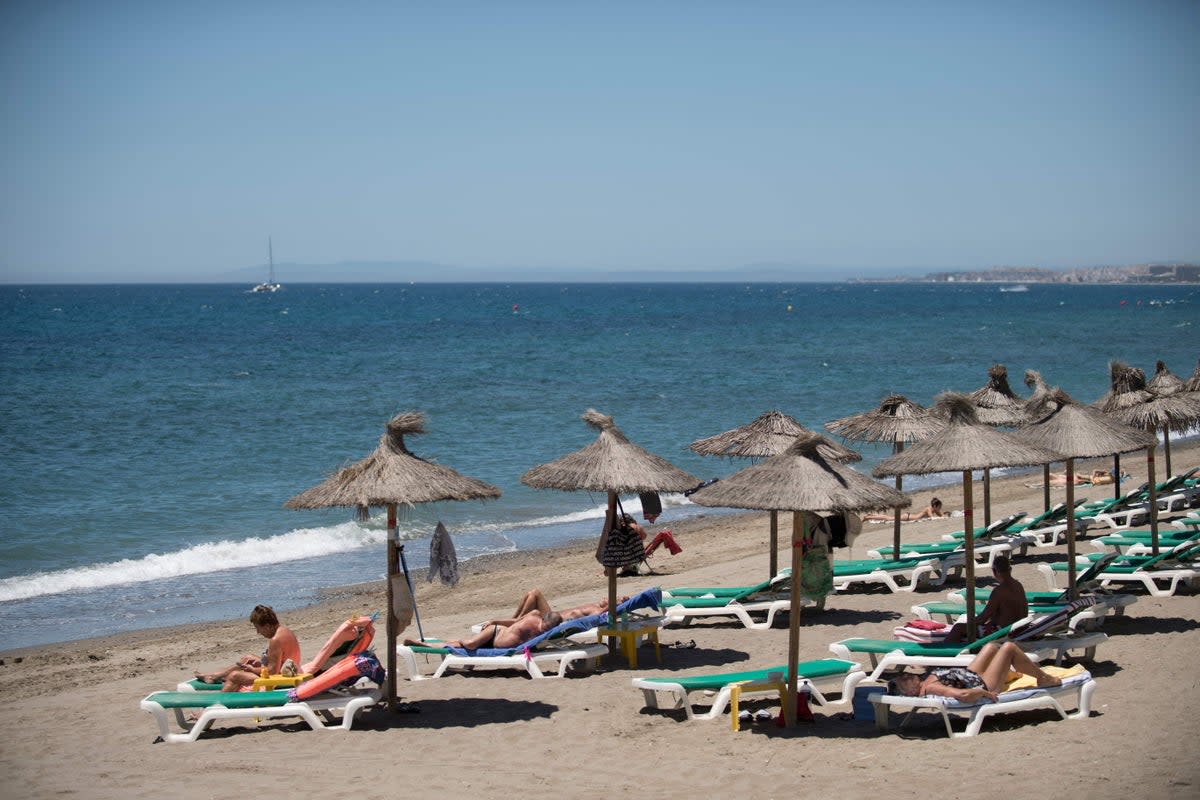 Tourists sunbathe on Marbella beach (AFP via Getty Images)