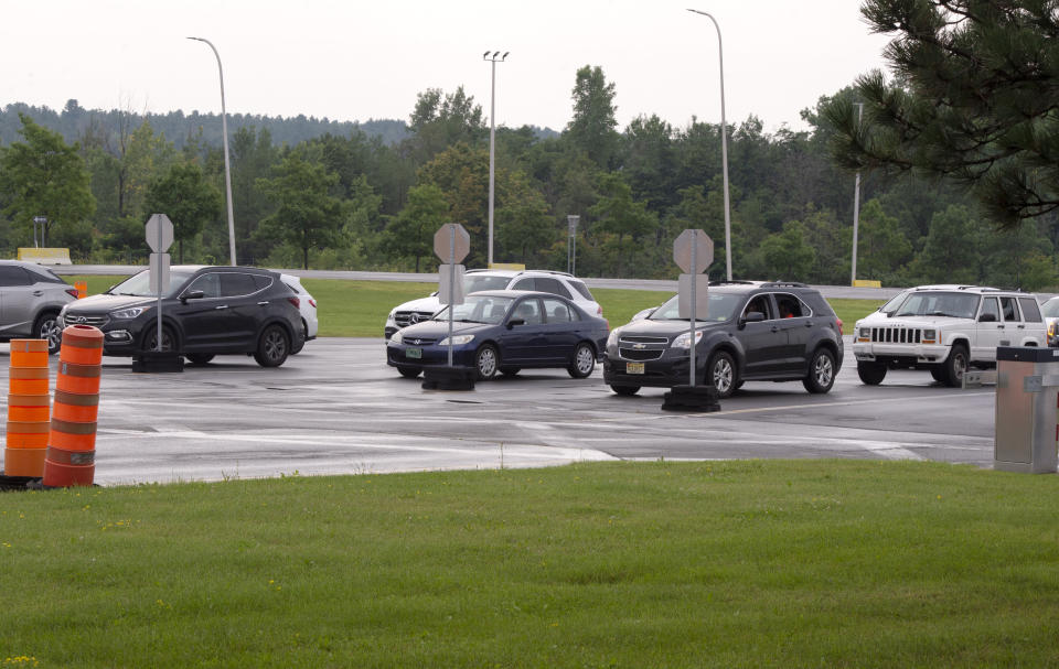 FILE - In this Aug. 9, 2021, file photo, cars line up at the border crossing at Lacolle, Quebec, Canada, south of Montreal as the border re-opens to fully vaccinated Americans. The Biden administration's decision to allow nonessential travel by vaccinated people to enter the U.S. by land starting Nov. 8 has many Canadians packing up their campers and making reservations at their favorite vacation condos and mobile home parks in warmer climes like Arizona, Florida and even Mexico. (Ryan Remiorz/The Canadian Press via AP, File)