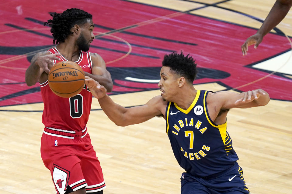 Indiana Pacers' Malcolm Brogdon (7) knocks the ball out of the hands of Chicago Bulls' Coby White of the during the first half of an NBA basketball game Saturday, Dec. 26, 2020, in Chicago. (AP Photo/Charles Rex Arbogast)