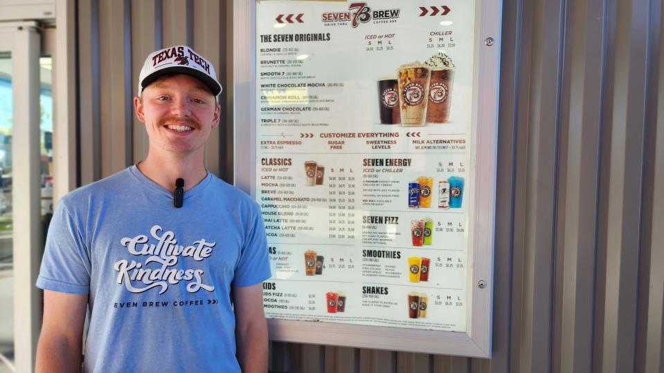 Noah Lockhart, manager of the new Amarillo location of 7 Brew, stands in front of his stand's menu Wednesday at the grand opening of the Western Street location in Amarillo.