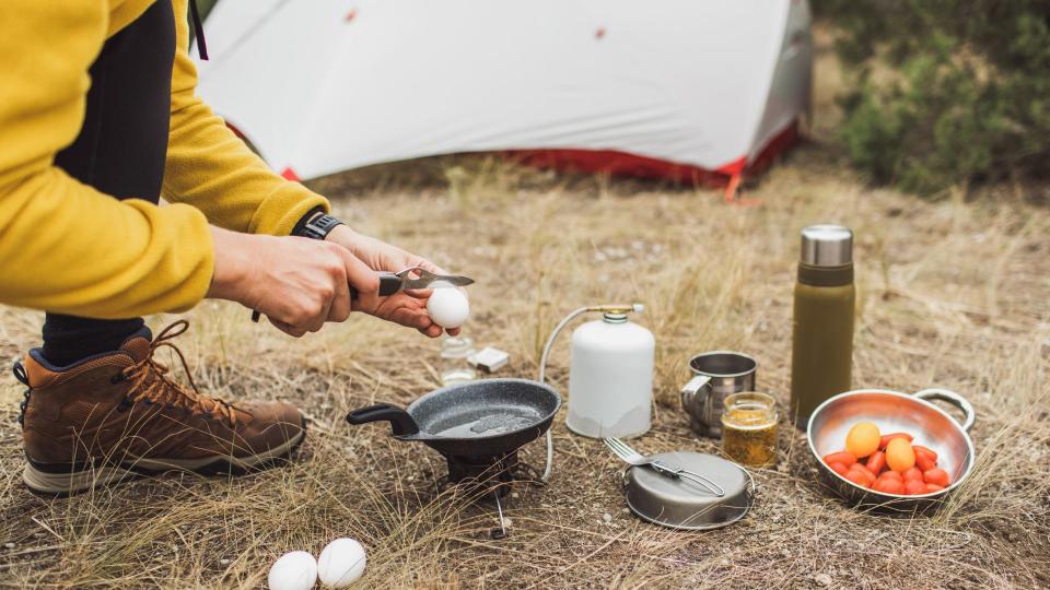 A person cutting eggs using a camping knife