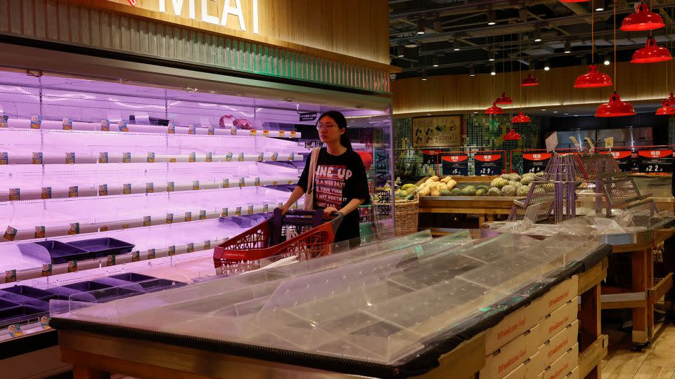 A customer walks past nearly empty shelves at a supermarket as Typhoon Saola approaches Hong Kong on August 31. - Tyrone Siu/Reuters