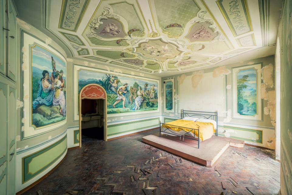 <p>Este dormitorio se encuentra en una enorme villa abandonada en el centro de Italia. El paso del tiempo se nota en el suelo, pero el techo y algunas paredes conservan su elegante decoración original. (Foto: <a rel="nofollow noopener" href="http://michaelschwan.de" target="_blank" data-ylk="slk:Michael Schwan" class="link ">Michael Schwan</a>). </p>