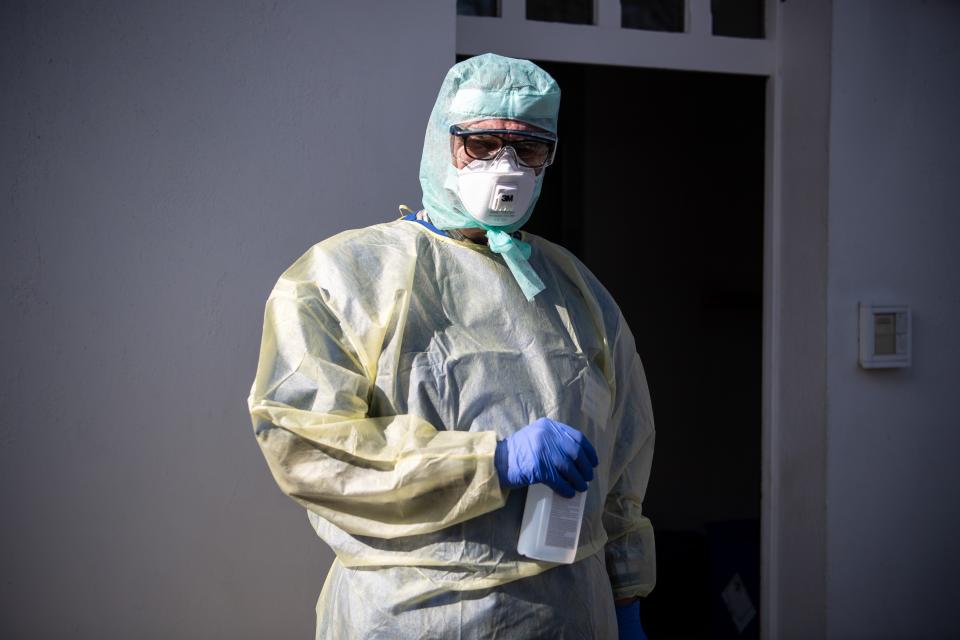 16 March 2020, Bremen: An employee from the Klinikum Bremen-Ost stands in protective clothing in front of the new corona outpatient clinic and receives patients. Photo: Sina Schuldt/dpa (Photo by Sina Schuldt/picture alliance via Getty Images)