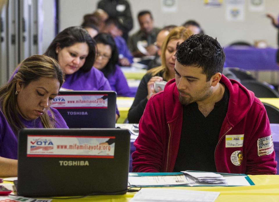 SEIU-UHW worker Kathy Santana, left , assists Ruben Torres, 27, during a health care enrollment event at SEIU-UHW office, Monday, March 31, 2014, in Commerce, Calif. Monday is the deadline to sign up for private health insurance in the new online markets created by President Barack Obama's health care law. (AP Photo/Ringo H.W. Chiu)