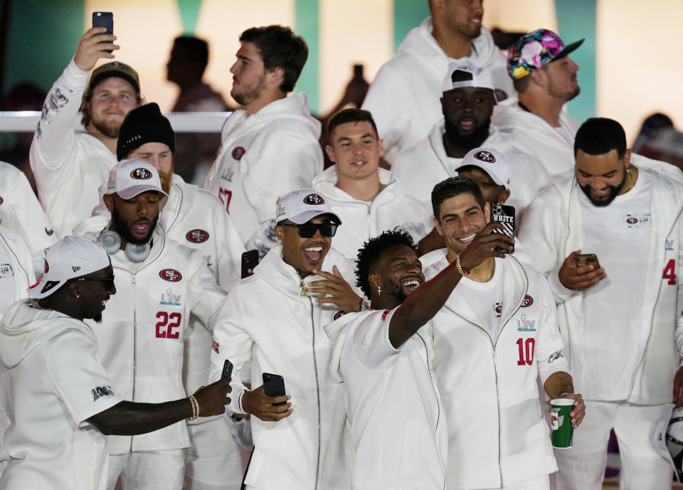 San Francisco 49ers take selfies as they arrive for Opening Night for the NFL Super Bowl 54 football game Monday, Jan. 27, 2020, at Marlins Park in Miami. (AP Photo/Morry Gash)