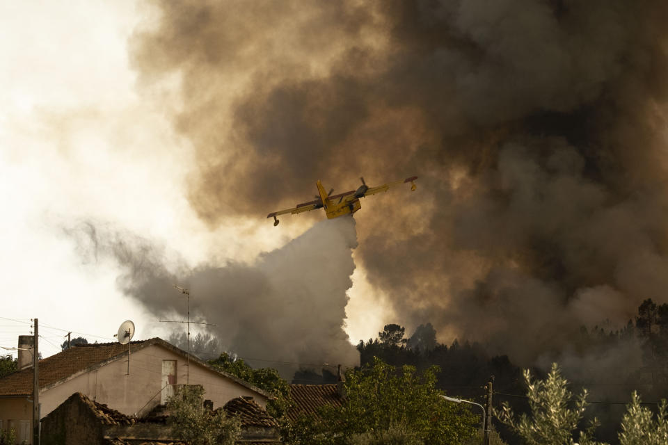 An airplane operates over a fire at the village of Chaveira, near Macao, in central Portugal on Monday, July 22, 2019. More than 1,000 firefighters are battling a major wildfire amid scorching temperatures in Portugal, where forest blazes wreak destruction every summer. About 90% of the fire area in the Castelo Branco district, 200 kilometers (about 125 miles) northeast of the capital Lisbon, has been brought under control during cooler overnight temperatures, according to a local Civil Protection Agency commander. (AP Photo/Sergio Azenha)