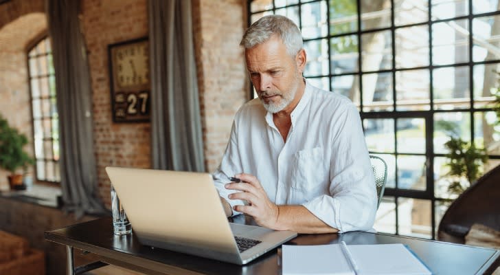 A man looks over his retirement savings on his laptop. 