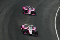 Helio Castroneves, of Brazil, leads Kyle Kirkwood as they head into the first turn during practice for the Indianapolis 500 auto race at Indianapolis Motor Speedway in Indianapolis, Friday, May 18, 2023. (AP Photo/Michael Conroy)