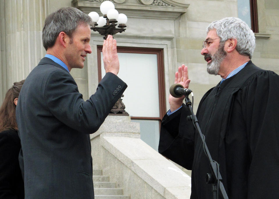 FILE - In this Jan. 7, 2013 file photo, Montana Supreme Court Chief Justice Mike McGrath, right, swears in Justice Brian Morris in Helena, Montana. Federal courts have delivered a string of recent rebukes to the Trump administration over its failures to protect the environment and stave off climate change as it moves to boost the energy industry. Some of the most far-reaching rulings have come from U.S. District Judge Morris, an Obama-appointee posted in Montana. (AP Photo/Matt Volz, File)